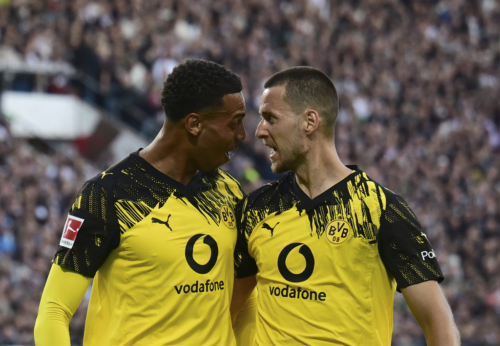 Dortmund's Waldemar Anton, right, celebrates with teammate Felix Nmecha after scoring during the German Bundesliga soccer match between FC St. Pauli and Borussia Dortmund at Millerntor Stadium in Hamburg, Germany, Saturday, Aug. 23, 2025. (Sina Schuldt/dpa via AP)