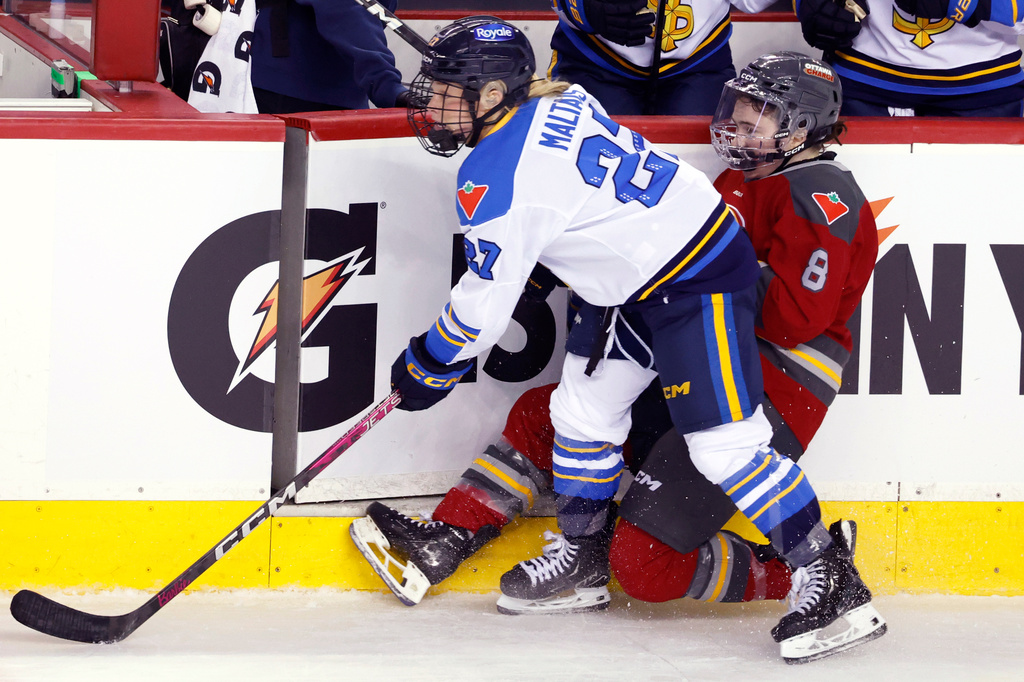 Toronto Sceptres' Emma Maltais, left, knocks down Ottawa Charge's Kathryn Reilly during second period PWHL Takeover Tour hockey action in Calgary, Wednesday, April 1, 2026. (Larry MacDougal/The Canadian Press via AP)