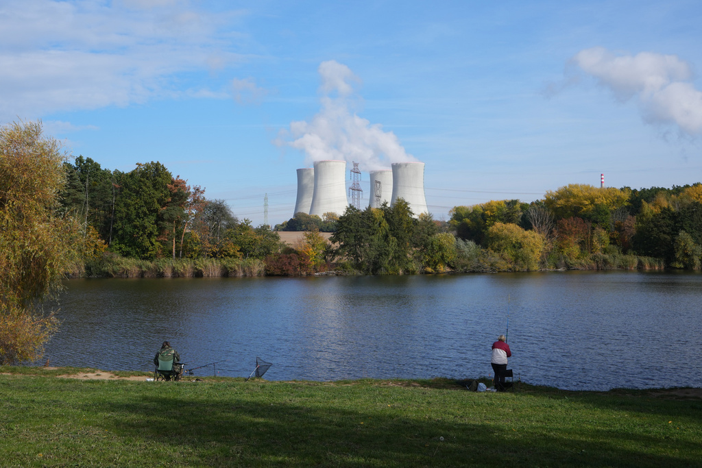 People fish near the towering Dukovany nuclear power plant, background, in Dukovany, Czech Republic, Oct. 21, 2025. (AP Photo/Petr David Josek)