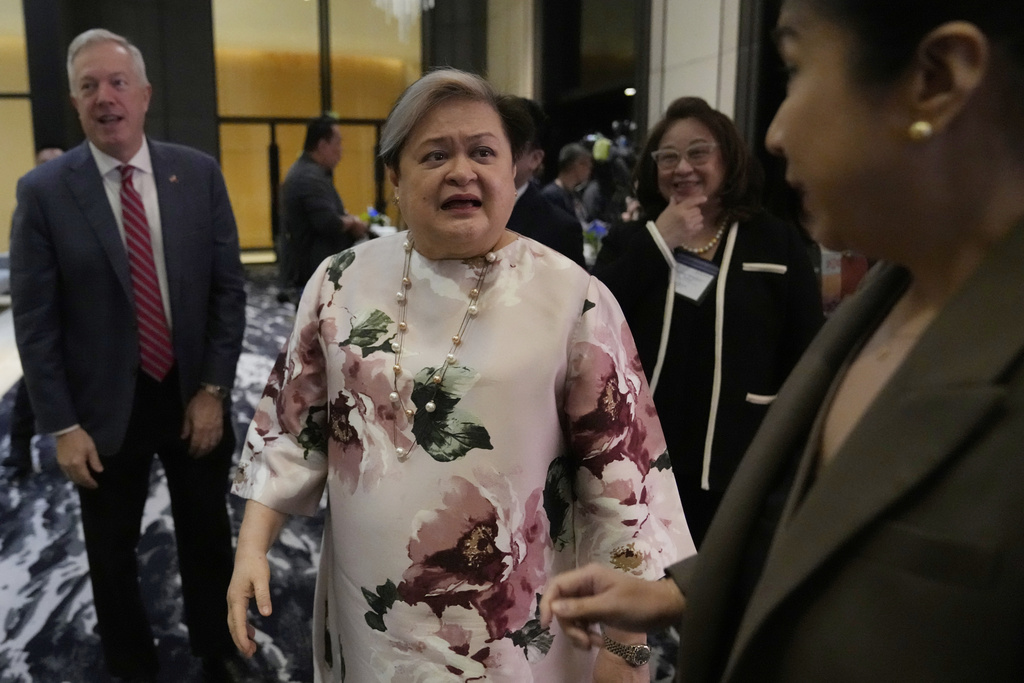 Philippine Foreign Secretary Theresa Lazaro, center, after attending a trade and investment conference at a hotel in Pasay, Philippines, on Thursday, Aug. 14, 2025. (AP Photo/Aaron Favila)