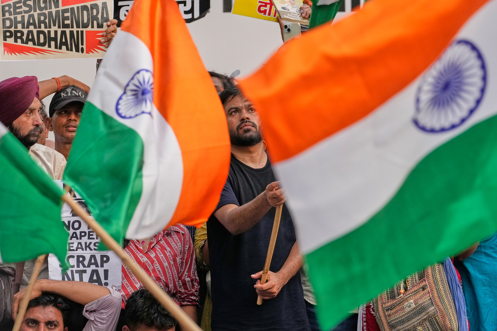 Abhijeet Dipke, founder of the Cockroach Janta Party furls Indian flag during a protest demanding the resignation of Education Minister Dharmendra Pradhan over alleged examination irregularities and repeated paper leaks in New Delhi, India, Saturday, June 20, 2026. (AP Photo/Manish Swarup)