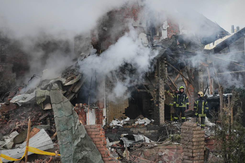Firefighters put out a fire after a drone hit a residential building during a Russian air attack in Kyiv, Ukraine, Sunday, Feb. 22, 2026. (AP Photo/Sergei Grits)