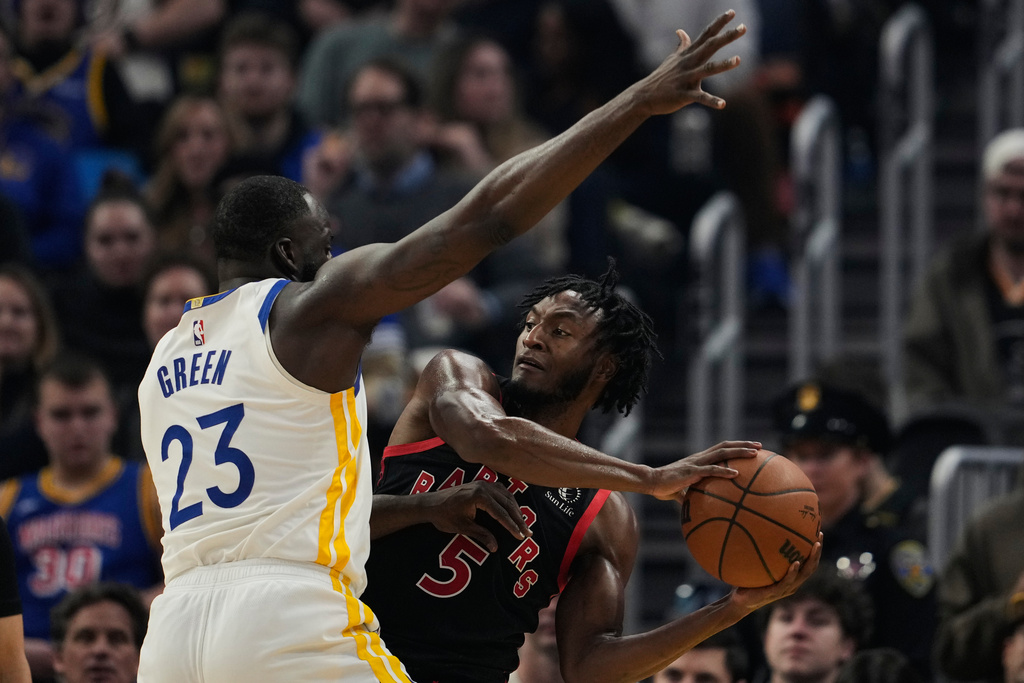 Toronto Raptors guard Immanuel Quickley (5) looks for an open teammate while defended by Golden State Warriors forward Draymond Green (23) during the first half of an NBA basketball game, Tuesday, Jan. 20, 2026, in San Francisco. (AP Photo/Godofredo A. Vásquez)