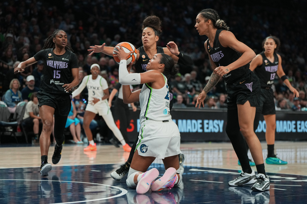 Minnesota Lynx forward Napheesa Collier, center front, controls the ball as Golden State Valkyries guard Veronica Burton, center top, defends during the first half of a WNBA basketball game Monday, Aug. 24, 2026, in Minneapolis. (AP Photo/Abbie Parr)