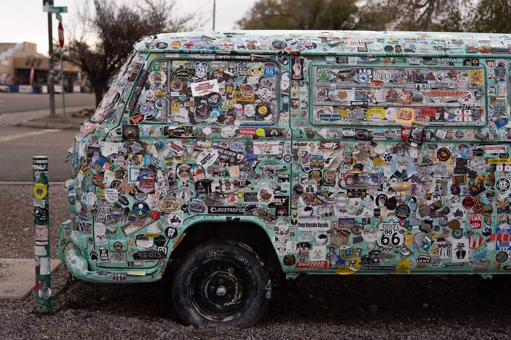 A vehicle covered in stickers is parked outside a souvenir shop in Seligman, Ariz., a town on historic Route 66, Friday, Nov. 21, 2025. (AP Photo/Jae C. Hong)
