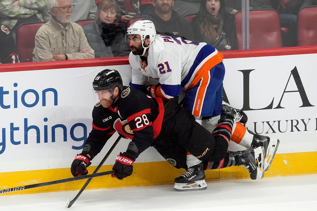 New York Islanders center Kyle Palmieri (21) knocks Ottawa Senators right wing Claude Giroux (28) to the ice during the first period of an NHL hockey game in Ottawa, Ontario, Saturday, Oct. 18, 2025. (Adrian Wyld/The Canadian Press via AP)