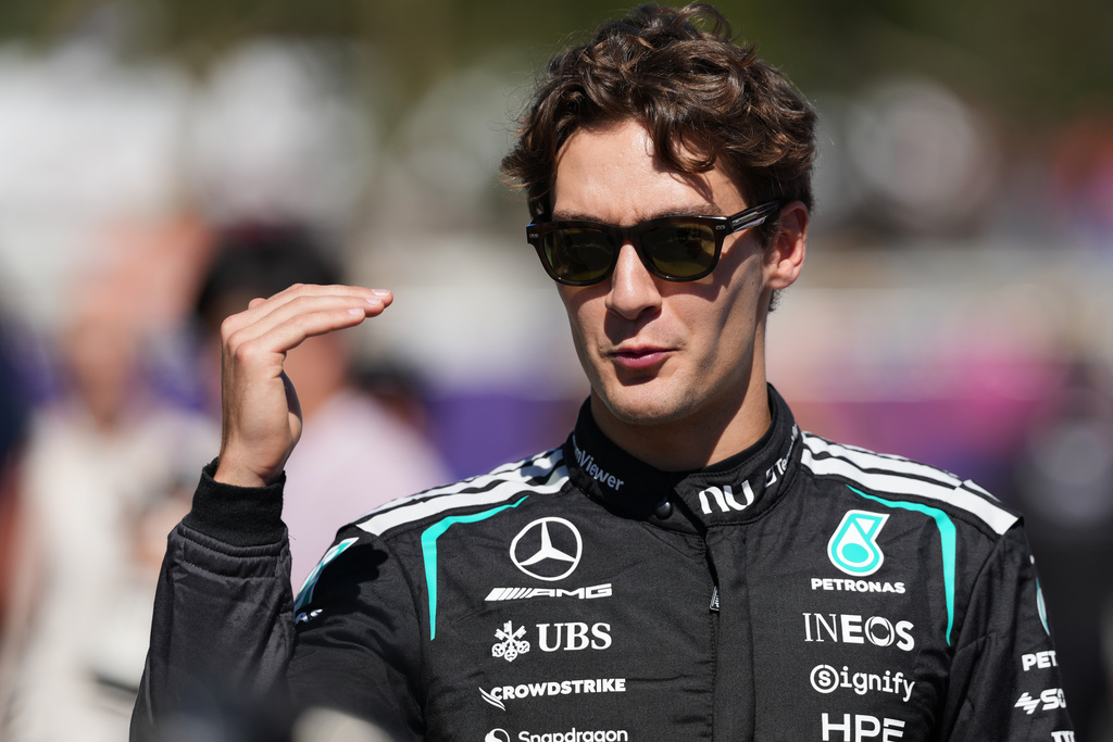 Mercedes driver George Russell of Britain gestures as he walks down the F1 Paddock ahead of the Australian Formula One Grand Prix at Albert Park, in Melbourne, Australia, Thursday, March 5, 2026. (AP Photo/Heath McKinley)