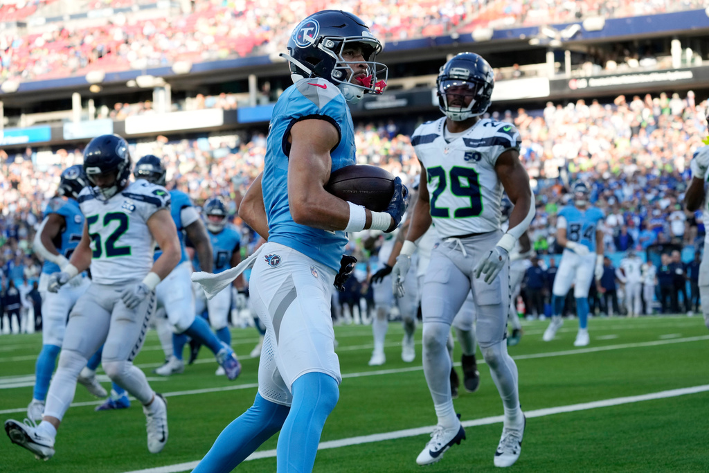 Tennessee Titans wide receiver Chimere Dike, center, scores a touchdown against the Seattle Seahawks during the second half of an NFL football game Sunday, Nov. 23, 2025, in Nashville, Tenn. (AP Photo/George Walker IV)