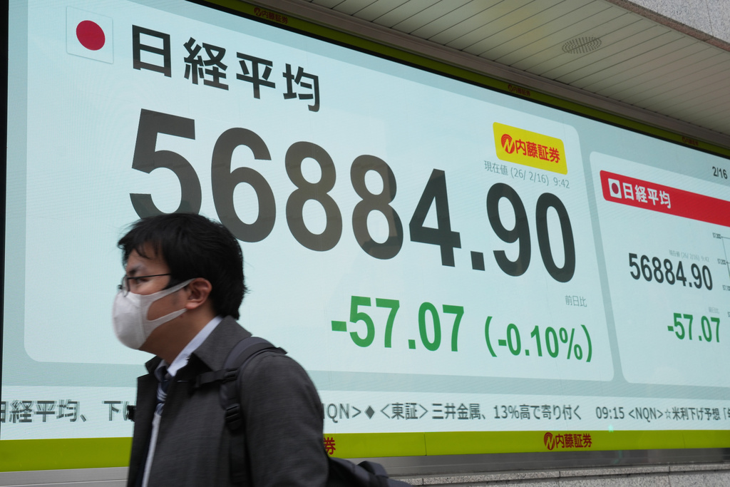 A person walks in front of an electronic stock board showing Japan's Nikkei index at a securities firm Monday, Feb. 16, 2026, in Tokyo. (AP Photo/Eugene Hoshiko)