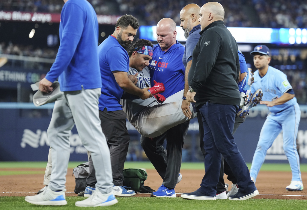 Chicago Cubs catcher Miguel Amaya (9) is tended to by medical staff and leaves the game during eighth inning MLB baseball action against the Toronto Blue Jays in Toronto on Wednesday, August 13, 2025. (Nathan Denette/The Canadian Press via AP)