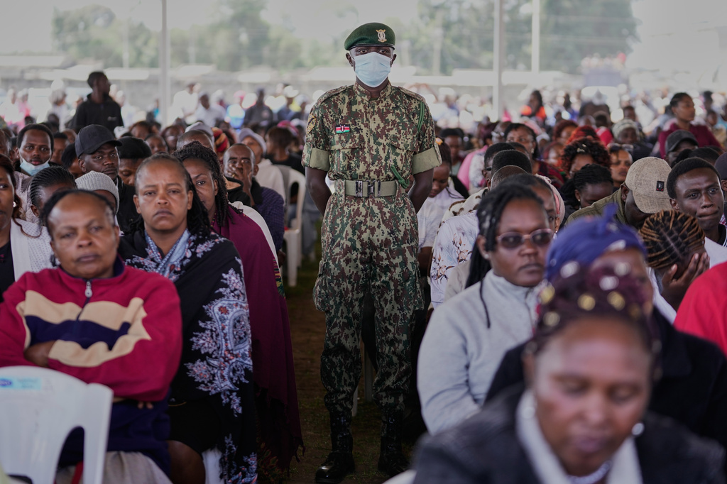 A member of Kenya's National Youth Service stands among mourners attending a memorial service for the 16 girls who died in the Utumishi Academy school fire at Gilgil Stadium, Nakuru County, Kenya, Friday, June 12, 2026. (AP Photo/Brian Inganga)