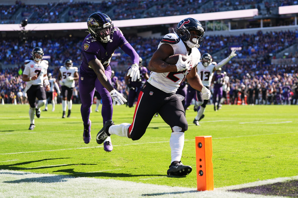 Houston Texans running back Nick Chubb (21) runs to the end zone for a touchdown against Baltimore Ravens safety Malaki Starks (24) during the second half of an NFL football game, Sunday, Oct. 5, 2025, in Baltimore. (AP Photo/Stephanie Scarbrough)