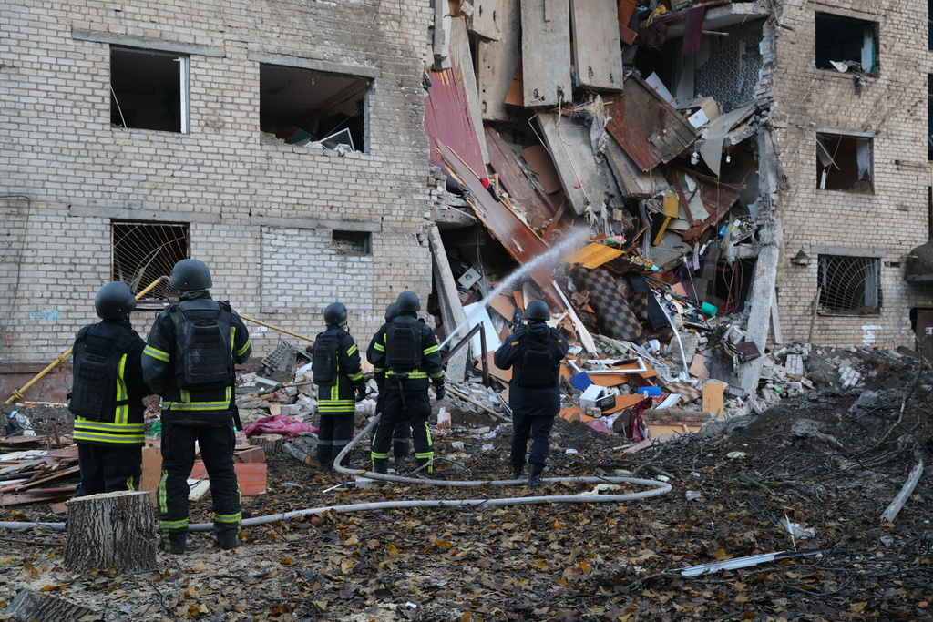 Rescuers attend to the scene after a Russian missile hit a hostel in Zaporizhzhia, Ukraine, Thursday, Oct. 30, 2025. (AP Photo/Kateryna Klochko)