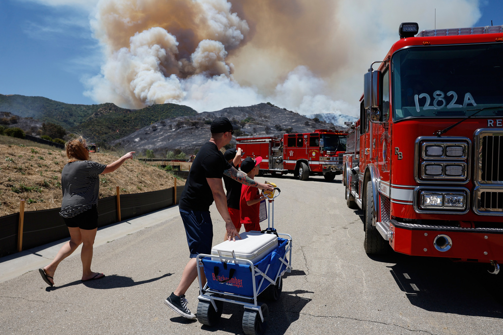 Matt and Kim Brantley bring firefighters snacks and refreshments with their kids during wildfires, Tuesday, May 19, 2026, in Simi Valley, Calif. (AP Photo/Caroline Brehman)