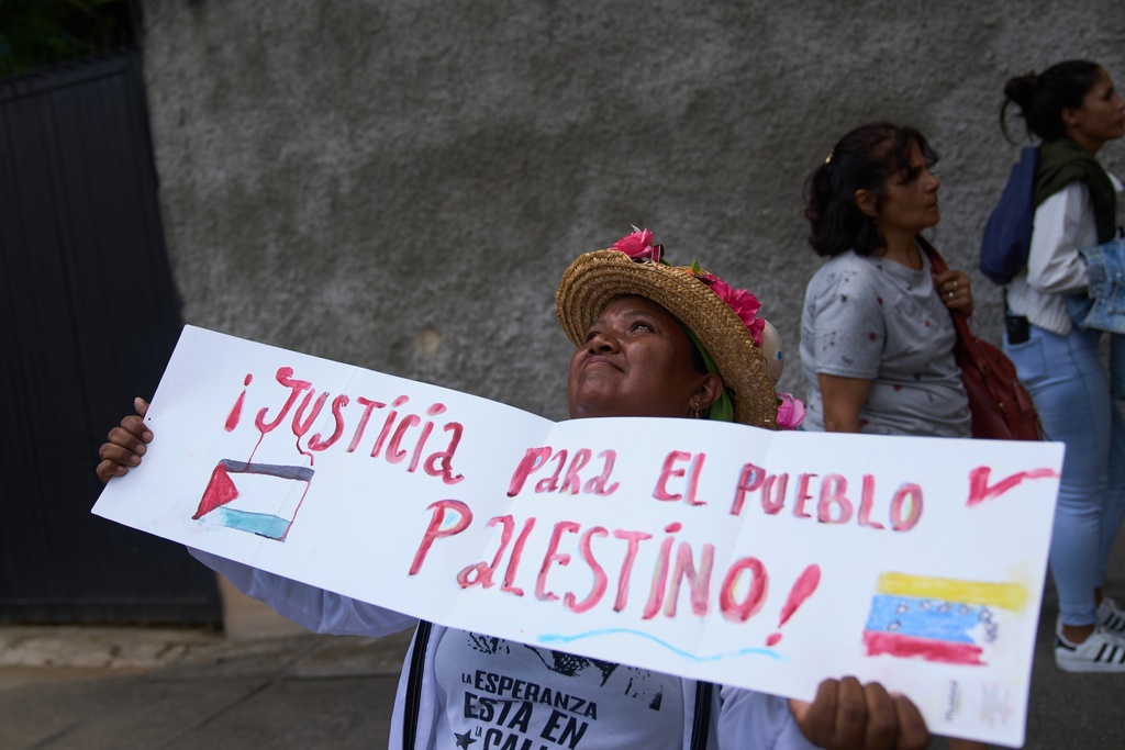 FILE - A woman holds a sign that reads in Spanish "Justice for Palestinian people" in Caracas, Venezuela, Tuesday, Oct 7, 2025, during a government rally in support of the Palestinian people and against Israel's offensive in Gaza. (AP Photo/Ariana Cubillos, File)