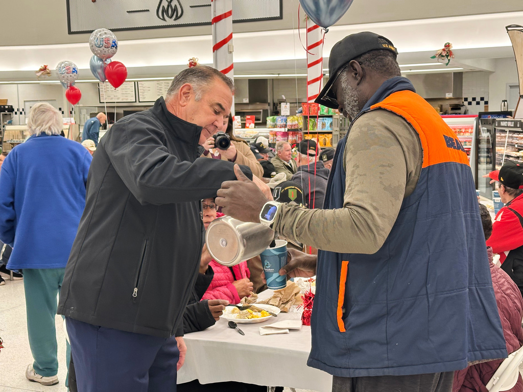 Missouri Gov. Mike Kehoe, left, pours a cup of coffee for an attendee at a Veterans Day breakfast, Tuesday, Nov. 11, 2025, at a Hy-Vee grocery story in Jefferson City, Mo. (AP Photo/David A. Lieb)