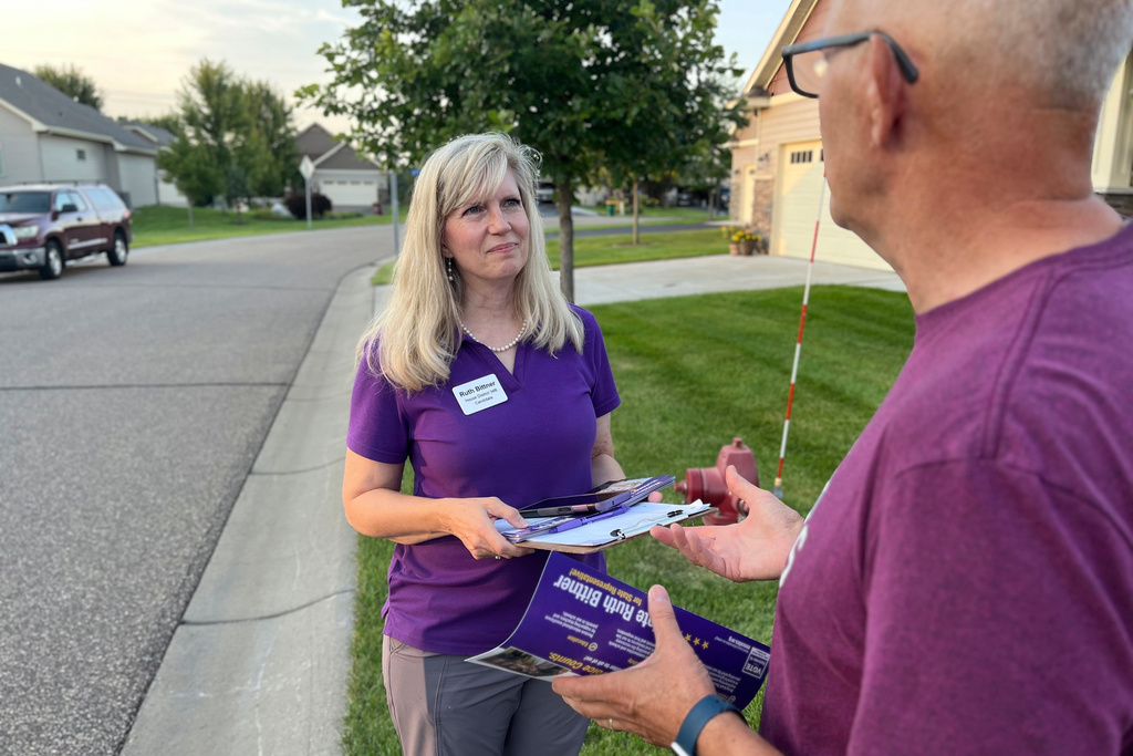 Republican candidate Ruth Bittner, who is running for the House District 34B seat, speaks with a potential voter while knocking on doors in Brooklyn Park, Minn., Thursday, Aug. 28, 2025. (Nathaniel Minor/Star Tribune via AP)