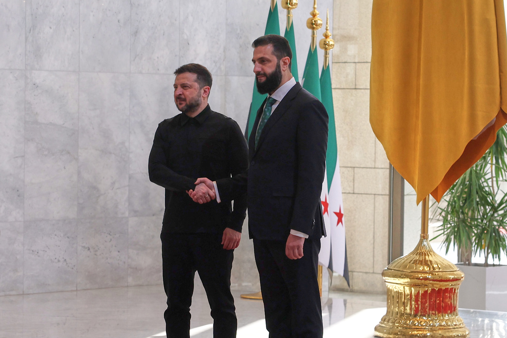 Syrian President Ahmad al-Sharaa, right, shakes hands with Ukrainian President Volodymyr Zelenskyy before a meeting at the People's Palace in Damascus, Syria, Sunday, April 5, 2026. (AP Photo/Ghaith Alsayed)