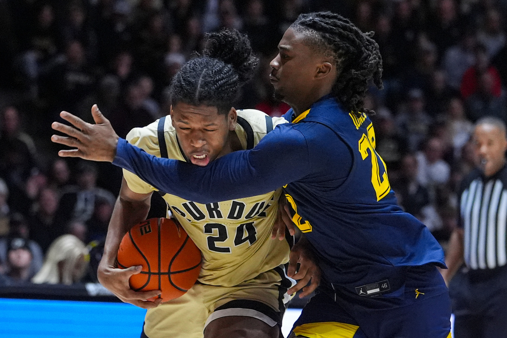 Purdue guard Gicarri Harris (24) is fouled by Marquette guard Sean Jones (22) during the second half of an NCAA college basketball game in West Lafayette, Ind., Saturday, Dec. 13, 2025. (AP Photo/Michael Conroy)