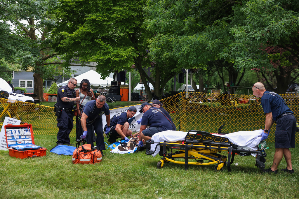 First responders help a woman who was injured the mass shooting that left 12 people injured at the Old West End Festival at the Agnes Reynolds Jackson Arboretum in Toledo on Saturday, June 6, 2026. (Rebecca Benson/The Blade via AP)