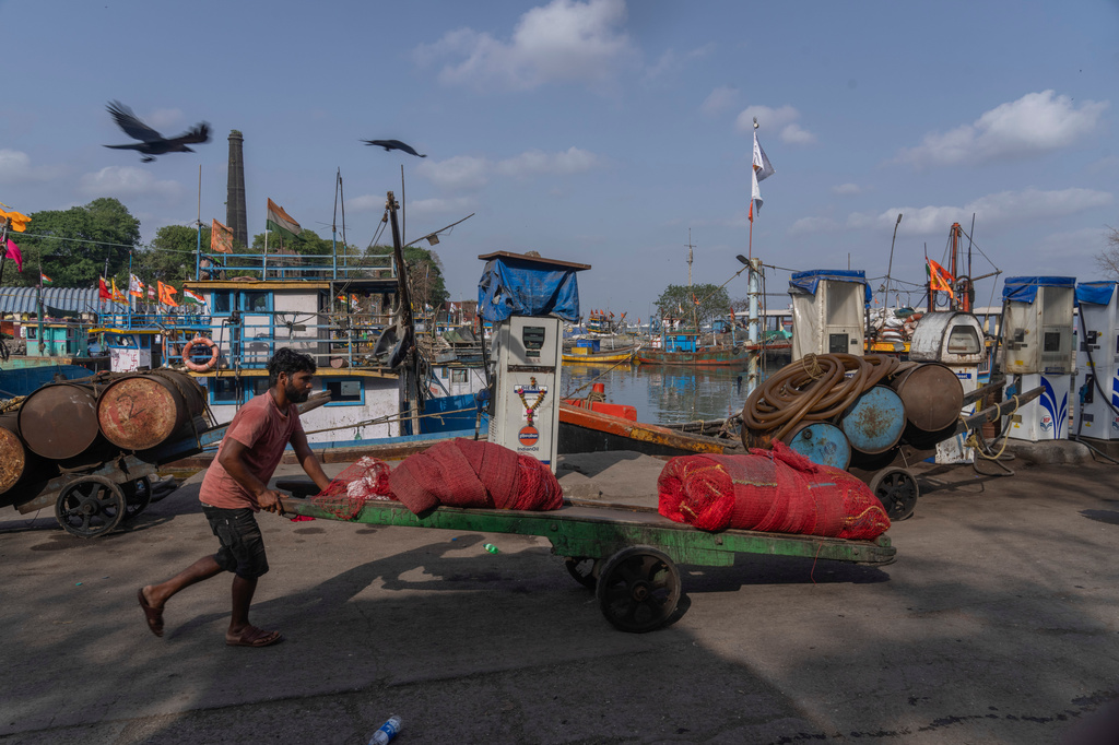 A deckhand pushes a handcart at Sassoon Dock beside a cooperative diesel pump that is shut due to rising bulk fuel prices in Mumbai, India, Tuesday, April 7, 2026. (AP Photo/Rafiq Maqbool)
