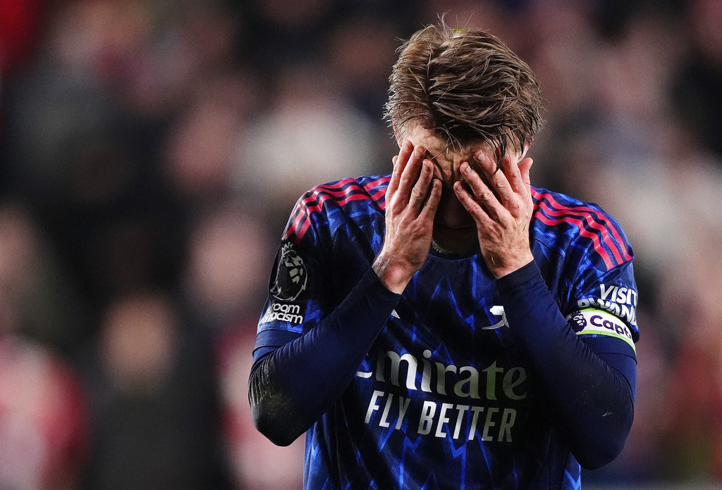 Arsenal's Martin Odegaard reacts after getting injured attempting to prevent Brentford's Keane Lewis-Potter from scoring during the English Premier League soccer match between Brentford and Arsenal in London, Thursday, Feb. 12, 2026. (John Walton/PA via AP)
