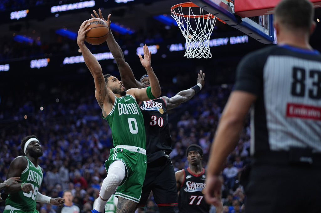 Boston Celtics' Jayson Tatum, left, goes up for a shot against Philadelphia 76ers' Adem Bona during the first half of Game 3 in a first-round NBA playoffs basketball series Friday, April 24, 2026, in Philadelphia. (AP Photo/Matt Slocum)