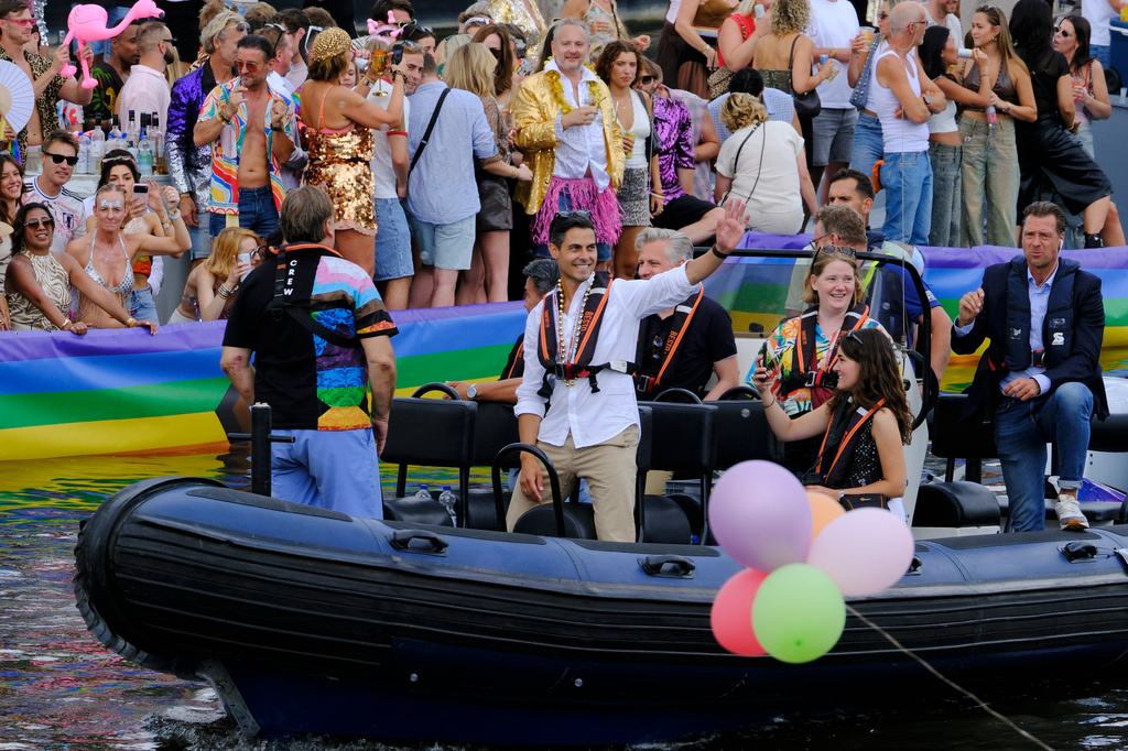 Netherland's Prime Minister Rob Jetten, center, waves as he rides on a boat, Saturday, Aug. 1, 2026, during the Canal Parade, the most popular event of the Pride Amsterdam festival that attracts tens of thousands of visitors to the city. (AP Photo/Patrick Post)