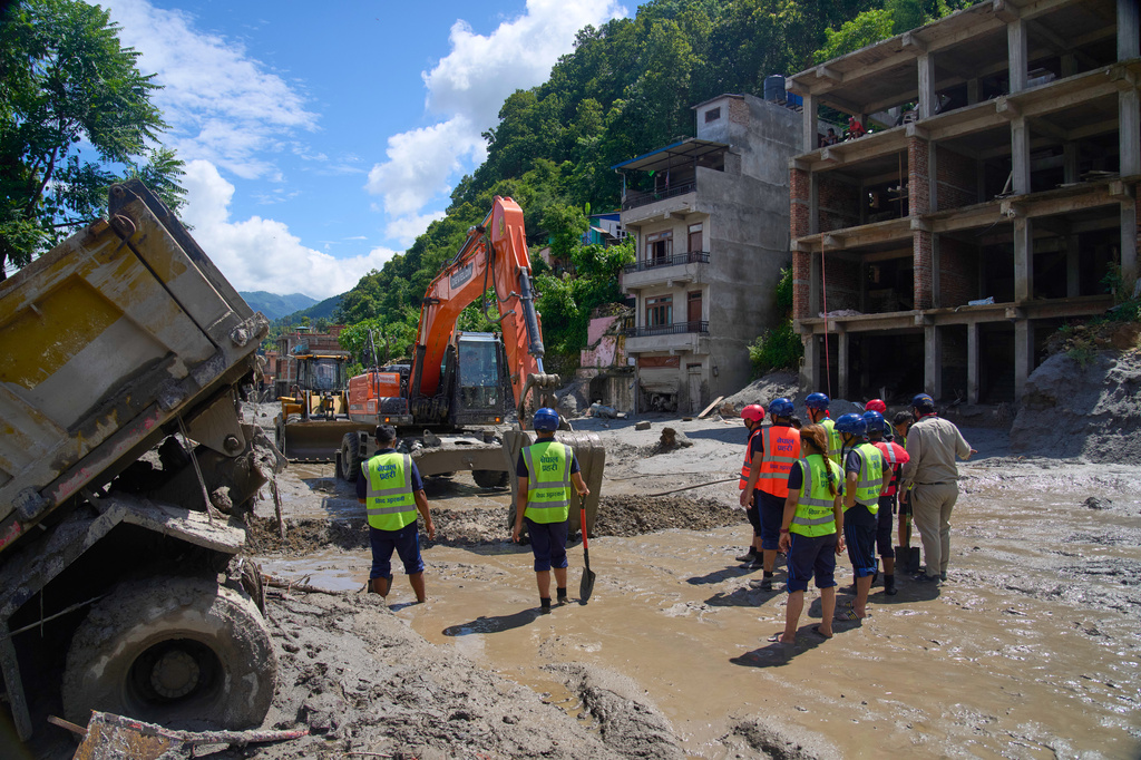 Earthmovers clear the debris from flash flooding in Nepal's Nuwakot district, Thursday, Aug. 27, 2026. (AP Photo/Niranjan Shrestha)