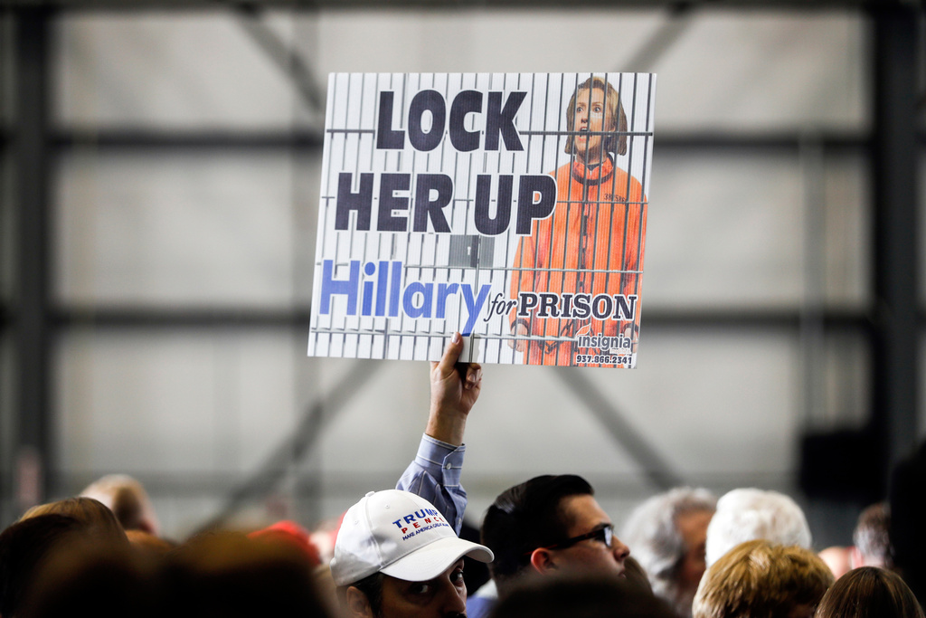 FILE - An attendee holds up a "Lock Her Up" sign before the arrival of Republican presidential candidate Donald Trump at a campaign rally, Nov. 4, 2016, in Wilmington, Ohio. (AP Photo/John Minchillo, file)