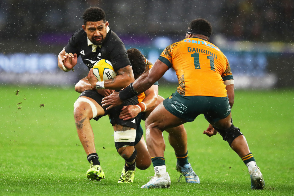 New Zealand's Ardie Savea, left, runs at Australia's Filipo Daugunu during the Bledisloe Cup rugby test between the All Blacks and the Wallabies in Perth, Australia, Saturday, Oct 4, 2025. (AP Photo/Gary Day)