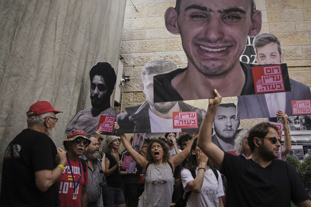 Demonstrators hold photos depicting the faces of Israeli hostages who are being held in the Gaza Strip, during a protest demanding their release from Hamas captivity and against the Israeli offensive in Gaza City, in Jerusalem, Tuesday, Sept. 16, 2025. (AP Photo/Mahmoud Illean)