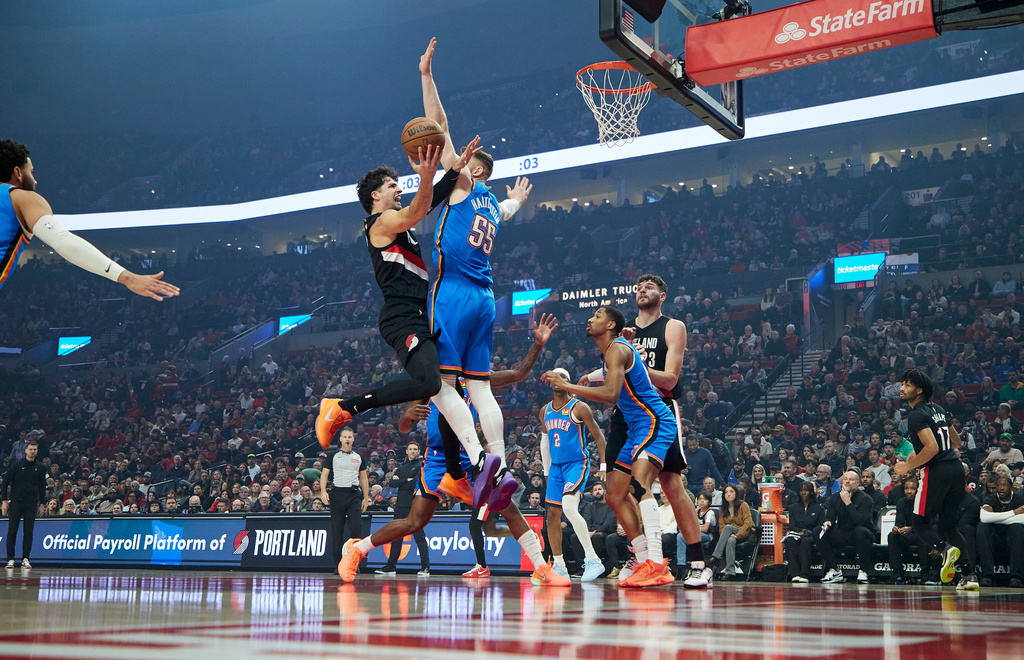 Portland Trail Blazers forward Deni Avdija, left, shoots over Oklahoma City Thunder center Isaiah Hartenstein during the first half of an NBA basketball game in Portland, Ore., Wednesday, Nov. 5, 2025. (AP Photo/Craig Mitchelldyer)