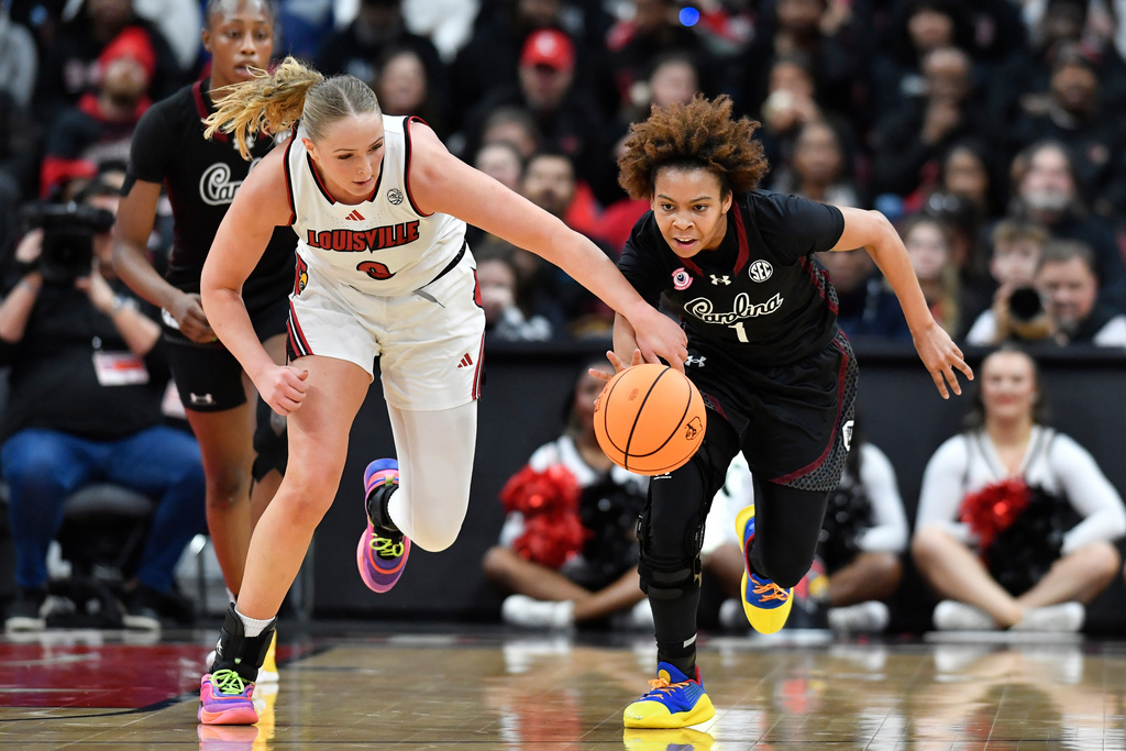 Louisville forward Laura Ziegler, front left, battles South Carolina guard Maddy McDaniel (1) for the ball during the first half of an NCAA college basketball game in Louisville, Ky., Thursday, Dec. 4, 2025. (AP Photo/Timothy D. Easley)