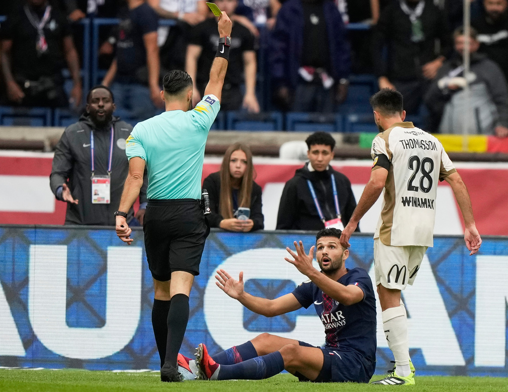 PSG's Goncalo Ramos, center, reacts as he receives a yellow card during the French League One soccer match between Paris Saint-Germain and Lens at the Parc des Princes stadium in Paris, Sunday, Sept. 14, 2025. (AP Photo/Michel Euler)