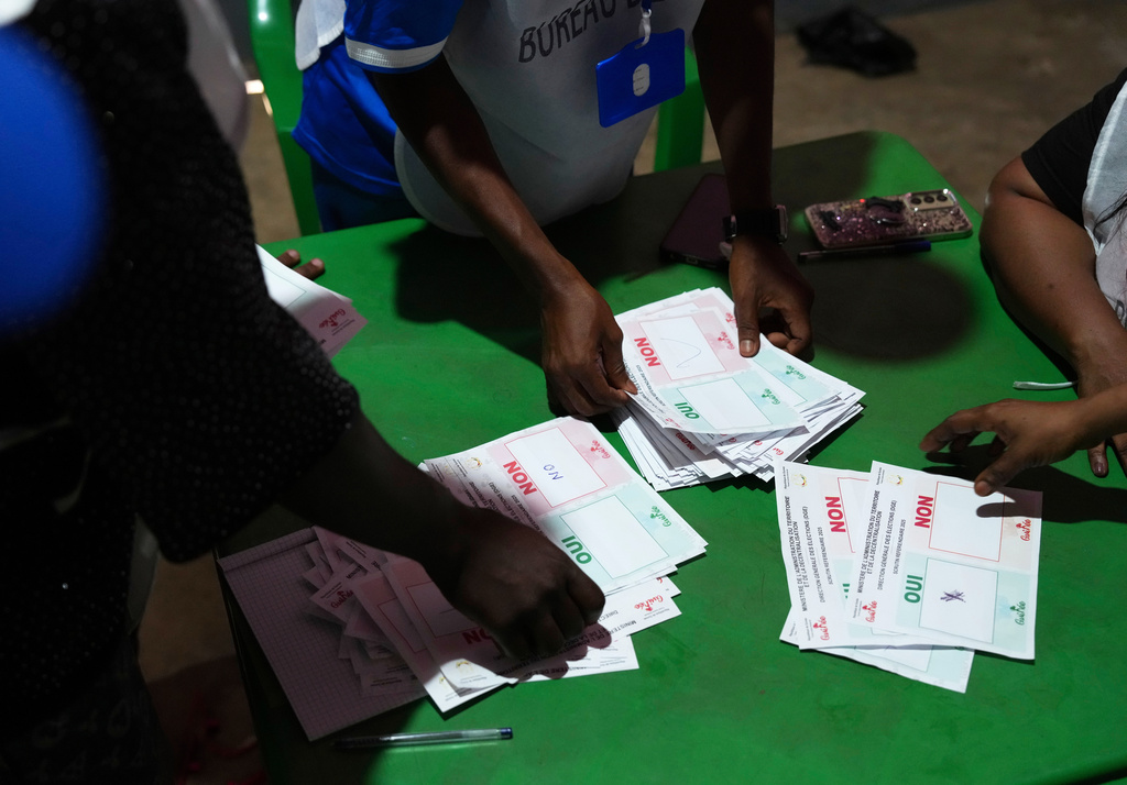 Officials count ballots at a polling station as polls close during the constitutional referendum in Conakry, Guinea, Sunday, Sept. 21, 2025. (AP Photo/Misper Apawu)
