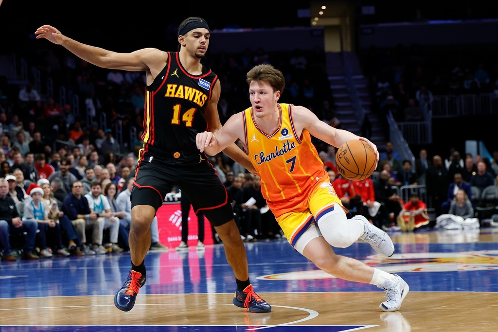 Charlotte Hornets guard Kon Knueppel (7) drives to the basket against Atlanta Hawks forward Asa Newell (14) during the first half of an NBA basketball game in Charlotte, N.C., Thursday, Dec. 18, 2025. (AP Photo/Nell Redmond)