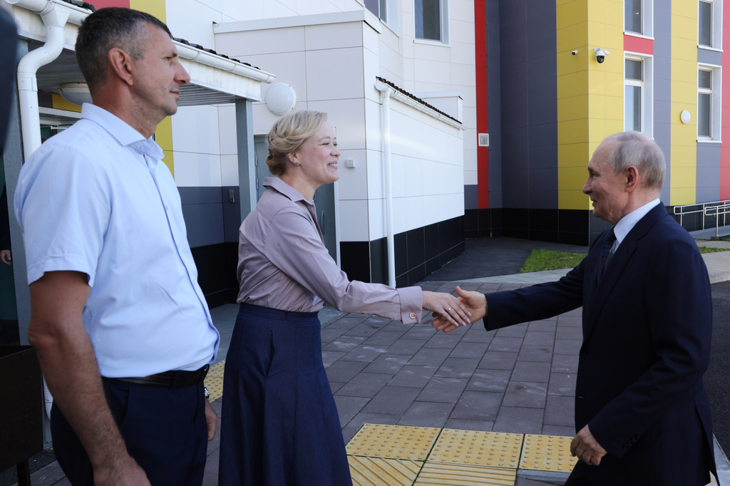Russian President Vladimir Putin, right, visits the Secondary School named after the Hero of Russia Eduard Norpolov in Kurilsk on the Iturup Island, the largest of the Kuril Islands of Russia's fareast, on Thursday, Aug. 13, 2026. (Gavriil Grigorov, Sputnik, Kremlin Pool Photo via AP)