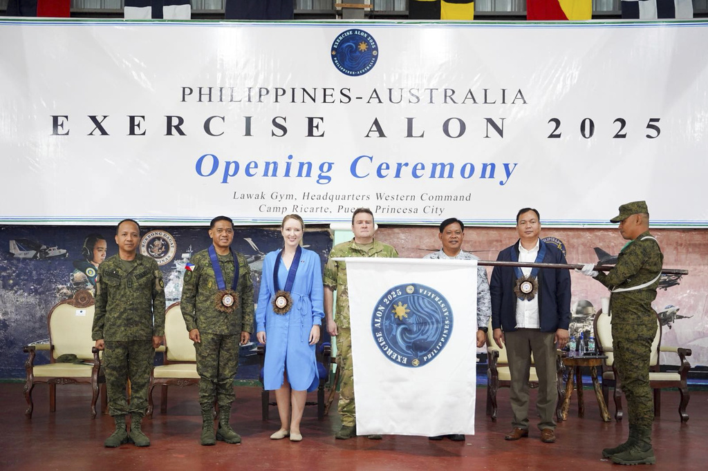 In this photo provided by the Armed Forces of the Philippines, from left, Maj. Gen. Francisco F Lorenzo Jr., commander of AFP Education, Training and Doctrine Command; military chief Gen. Romeo Brawner Jr., Deputy Ambassador of Australia to the Philippines Moya Collett, Vice Adm. Alfonso F Torres Jr., Commander of Western Command, Donald D. Ocampo, Acting Head, DFA Consular Office in Puerto Princesa, and Deputy Chief of Joint Operations Maj. Gen. Hugh McAslan stand together as the exercise flag unfurls during the opening ceremony of joint military drills between Australia and the Philippines in Palawan province, Philippines on Friday, Aug. 15, 2025. (Armed Forces of the Philippines via AP)