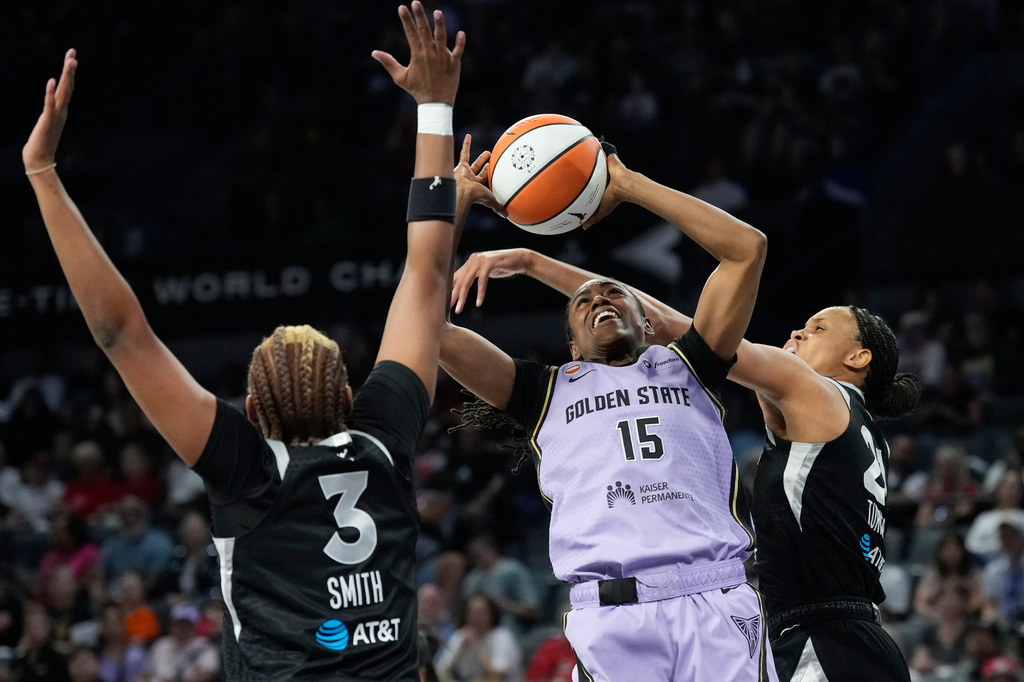Golden State Valkyries guard Tiffany Hayes (15) shoots over Las Vegas Aces forward Nalyssa Smith (3) and Las Vegas Aces forward-center Brianna Turner, right, during the first half of a WNBA basketball game Sunday, June 21, 2026, in Las Vegas. (AP Photo/John Locher)