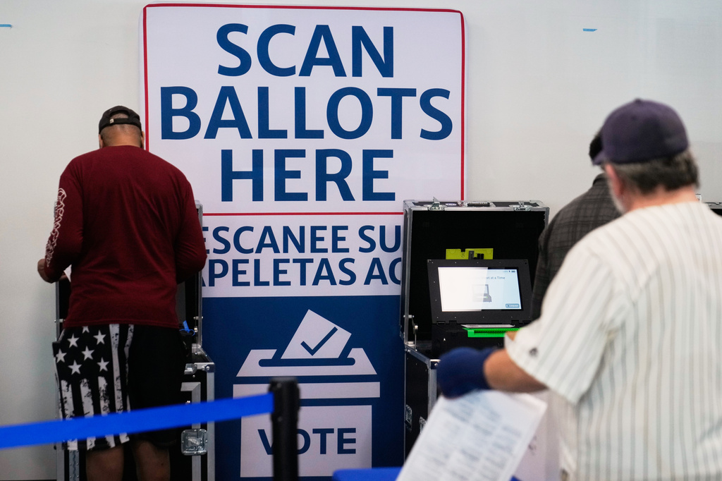 Voters scan their ballots at early in-person voting in Cleveland, Wednesday, Oct. 7, 2026. (AP Photo/Sue Ogrocki)