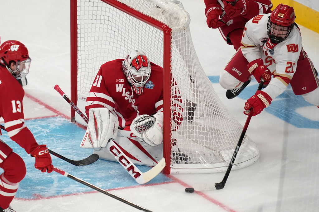Denver forward Clarke Caswell (25) attempts a shot on Wisconsin goaltender Daniel Hauser (31) in the first period of the championship game at the NCAA Frozen Four men's college hockey tournament Saturday, April 11, 2026, in Las Vegas. (AP Photo/John Locher)