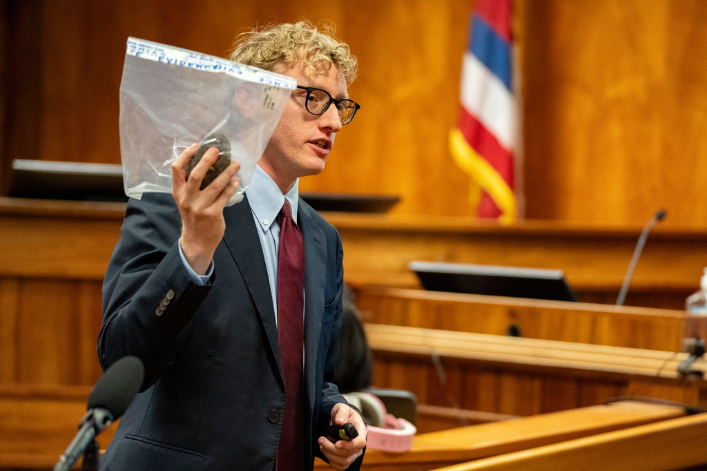 Deputy Prosecutor Joel Garner holds a rock as evidence while presenting closing arguments during the attempted murder trial of Gerhardt Konig in a courtroom, Tuesday, April 7, 2026, in Honolulu. (AP Photo/Mengshin Lin, Pool)