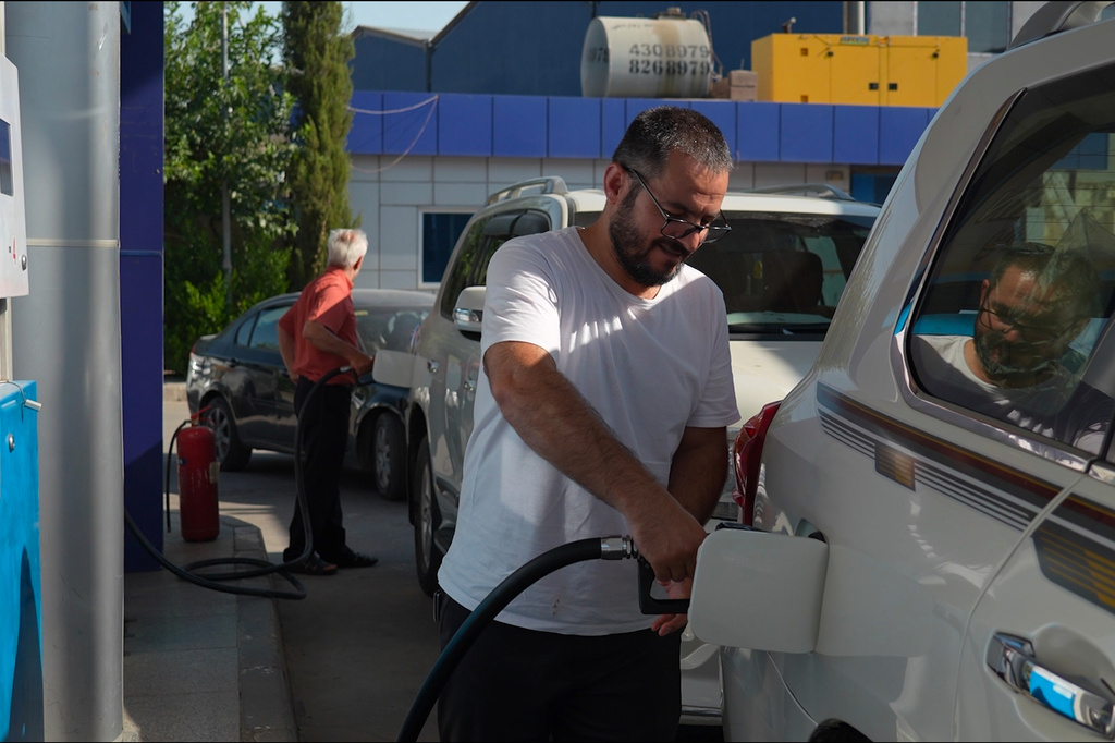 People pump gasoline into their car at a gas station during a fuel shortage in Irbil, Iraq, Tuesday, July 28, 2026. (AP Photo/Stella Martany)