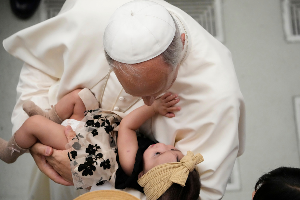 FILE - Pope Leo XIV cradles a baby girl during his weekly general audience, at the Vatican, Aug. 20, 2025. (AP Photo/Gregorio Borgia, File)