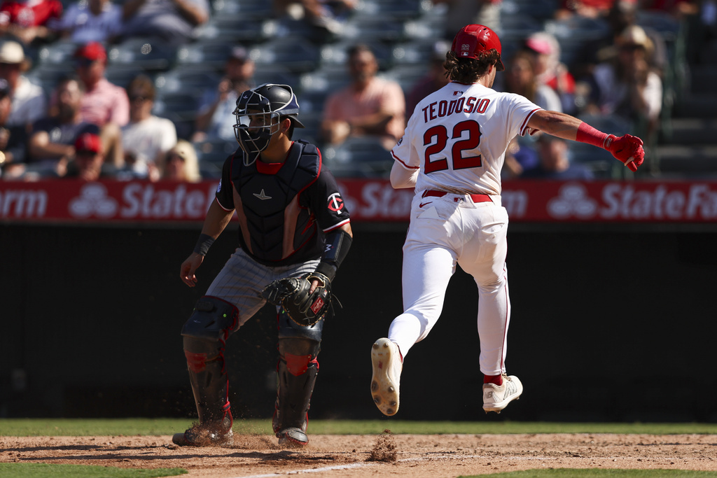 Los Angeles Angels' Bryce Teodosio (22) runs towards home plate to score off of a sacrifice fly by Mike Trout as Minnesota Twins catcher Mickey Gasper, left, watches during the eighth inning of a baseball game, Wednesday, Sept. 10, 2025, in Anaheim, Calif. (AP Photo/Jessie Alcheh)