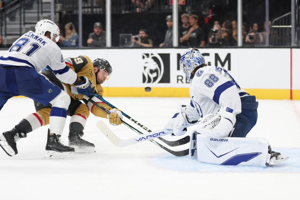 Tampa Bay Lightning defenseman Erik Cernak (81) defends Vegas Golden Knights left wing Ivan Barbashev (49) while goaltender Andrei Vasilevskiy (88) stops Barbashev's shot during the second period of an NHL hockey game Thursday, Nov. 6, 2025, in Las Vegas. (AP Photo/Ian Maule)