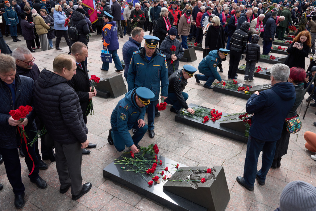Russian Emergency Ministry troops and veterans lay flowers at the graves of firefighters at the Mitinskoye Cemetery where several victims of the Chernobyl nuclear disaster are buried, marking the 40th anniversary of the explosion and fire at the Chernobyl nuclear power plant in Ukraine, outside Moscow, Sunday, April 26, 2026. (AP Photo/Alexander Zemlianichenko)