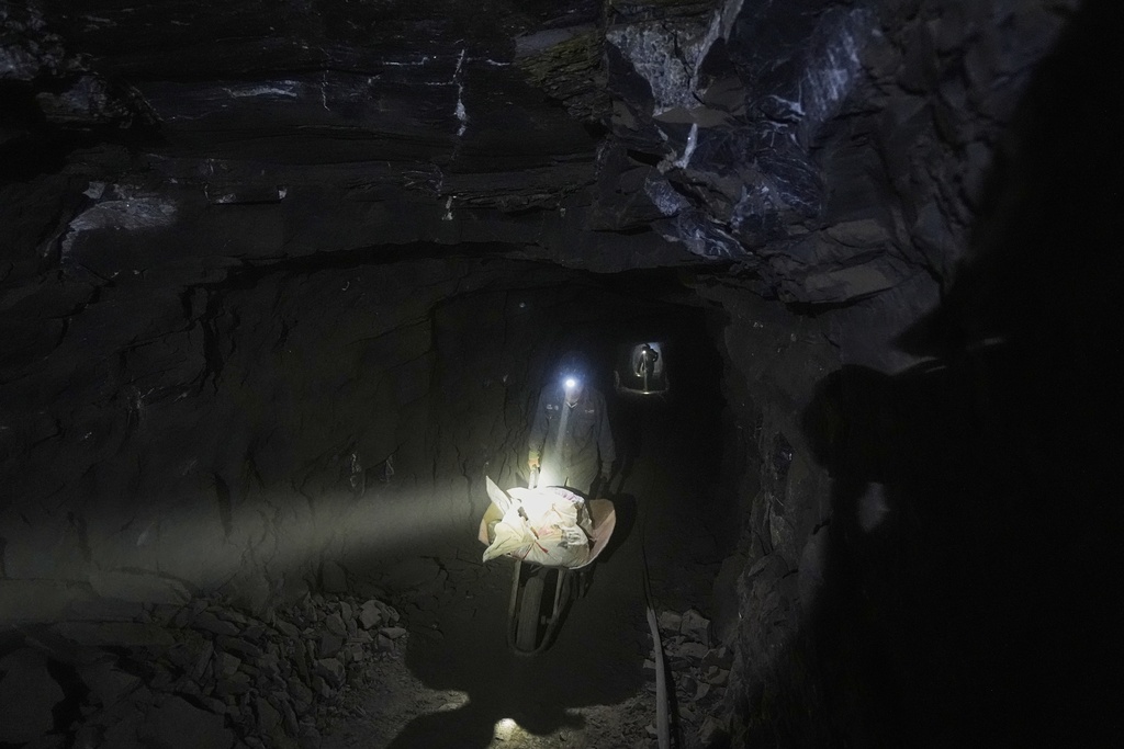 Miners transport sacks of mercury ore with the help of a cart in San Joaquin, Mexico, Tuesday, Aug. 19, 2025. (AP Photo/Fernando Llano)