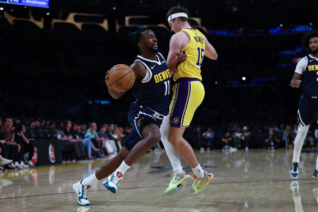 Denver Nuggets forward Alpha Diallo (11) drives past Los Angeles Lakers guard Austin Reaves (15) during the second half of a preseason NBA basketball game, Friday, Oct. 16, 2026, in Los Angeles. (AP Photo/Ben Liebenberg)